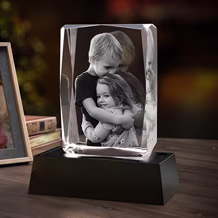 3D Crystal Gem Rectangle Tall with an engraved portrait of two children hugging, displayed on a black LED light base.